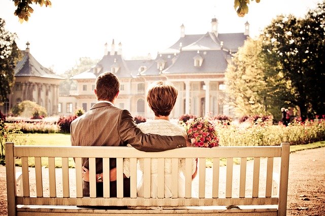 couple sitting on a bench looking at a beautiful wedding place